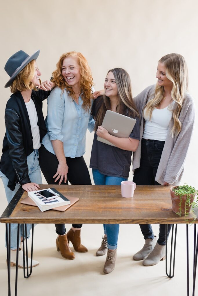 a group of women standing around a wooden table